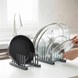 Hands organizing pot lids in rack